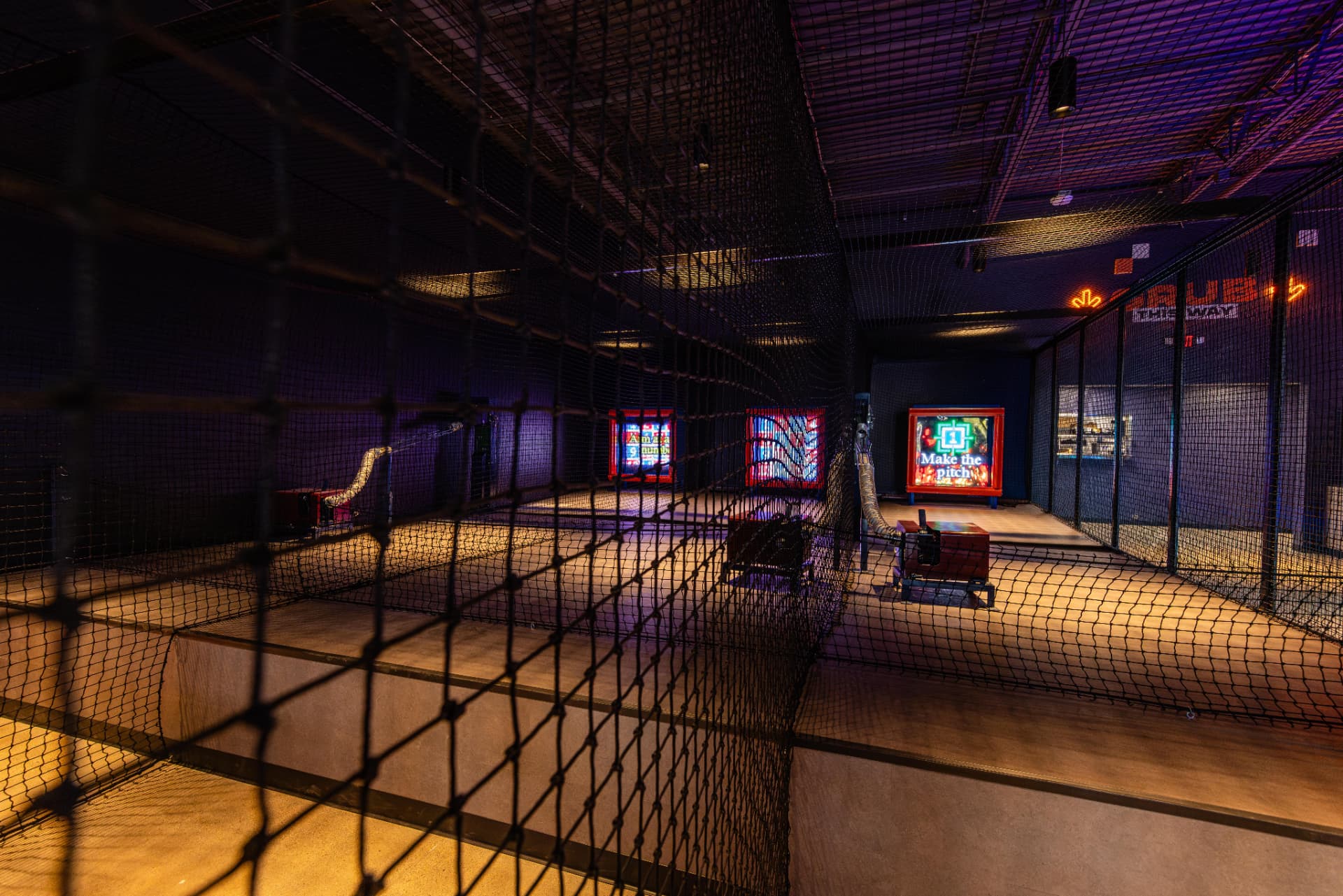 An indoor pitching lane with illuminated target screens at Taroko Sports